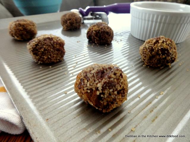 A close-up shot of rolled, unbaked Mexican Chocolate Cookies dipped in coarse sugar to show texture.