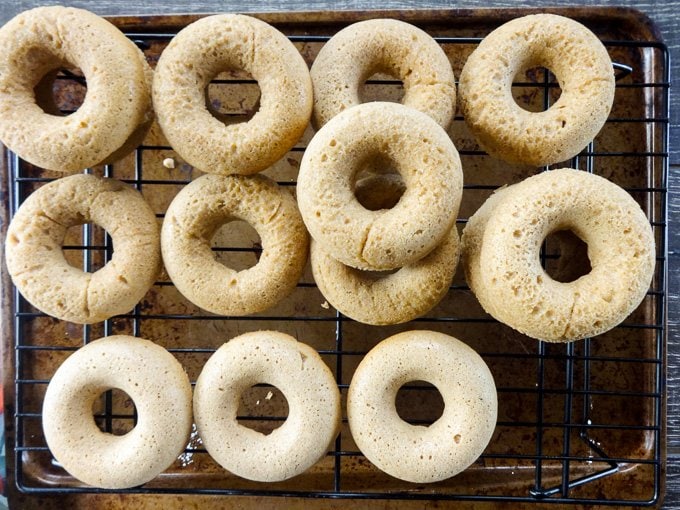 Unglazed baked donuts on a wire cooling rack. 