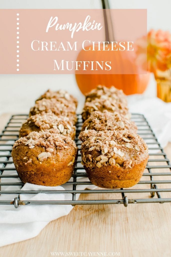 A cooling wire rack with pumpkin cream cheese streusel muffins and a pumpkin in the background.