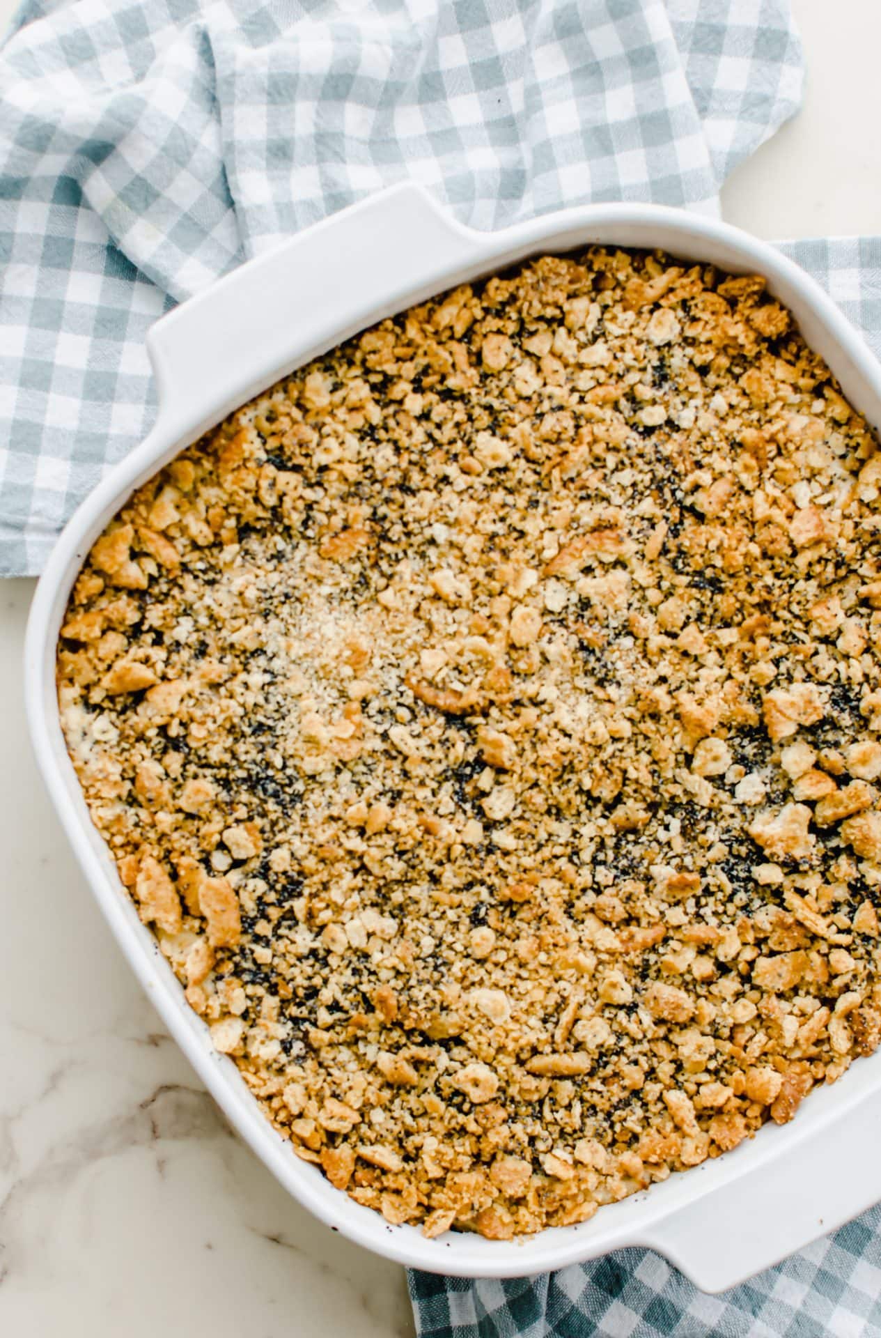 Baked poppy seed chicken casserole in a white baking dish. 