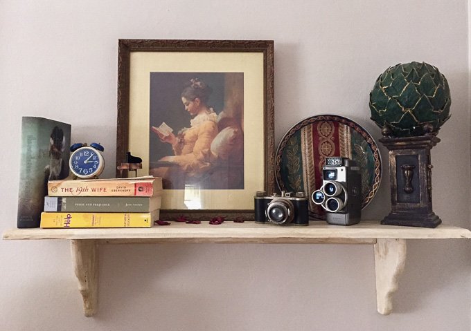 This shelf features a collection of vintage cameras, old books, and some decor odds and ends from Poppy's house www.sweetcayenne.com