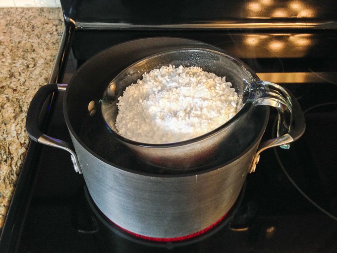 Pot of melting soy candle wax on stove.