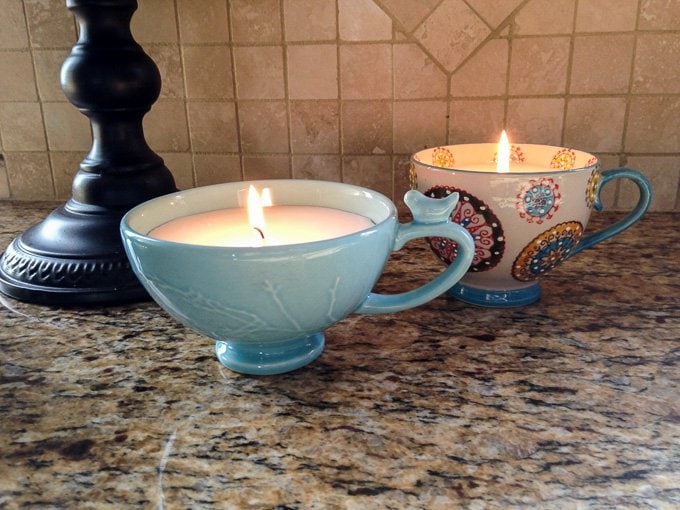 Coffee Cup Candles lit on a marble kitchen counter.