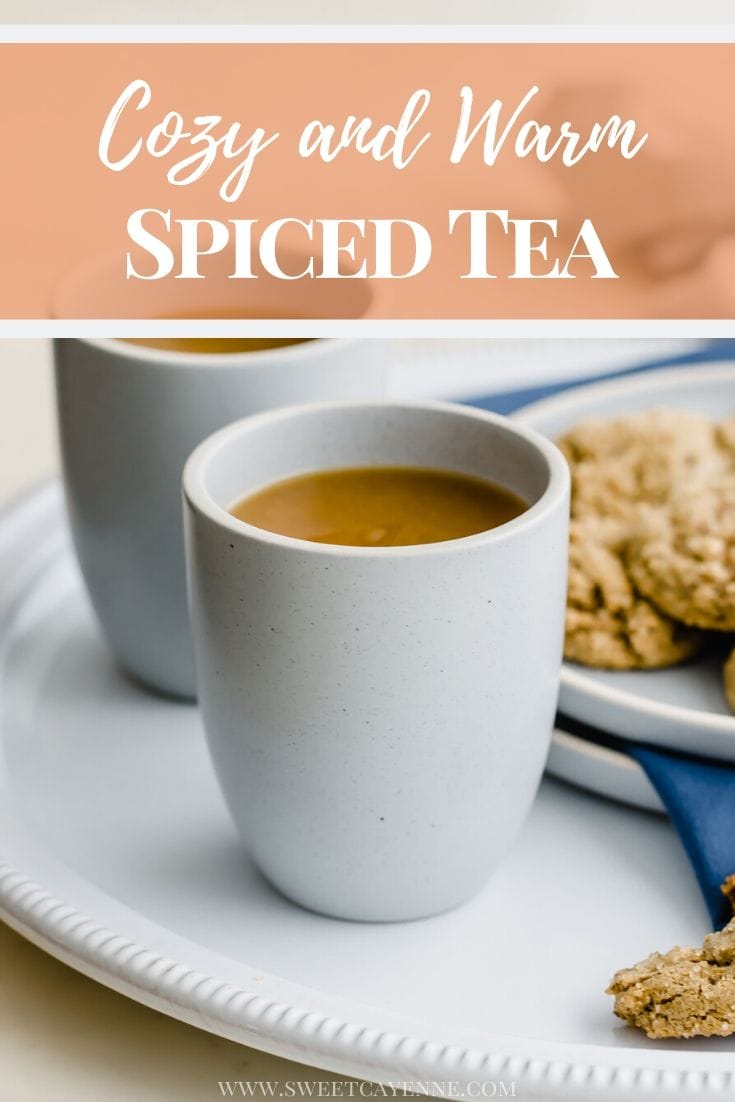 Two blue stone cups of spiced tea on a white platter with a plate of ginger cookies on the side.