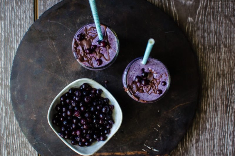 Chocolate Covered Wild Blueberry Superfoods Smoothie is made with highly flavored wild blueberries and packed with nutrition! A chocolate-coconut oil mixture is drizzled into the smoothie and blended, turning it into little chips of chocolate in the smoothie. It's like homemade magic shell in your drink!