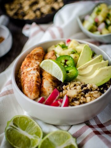 If you like "bowl food," you'll love this fresh and flavorful taco bowls with spicy pan-seared fish, plantain fried rice, black beans, and a juicy pineapple salsa! A fun take on an easy fish taco recipe.