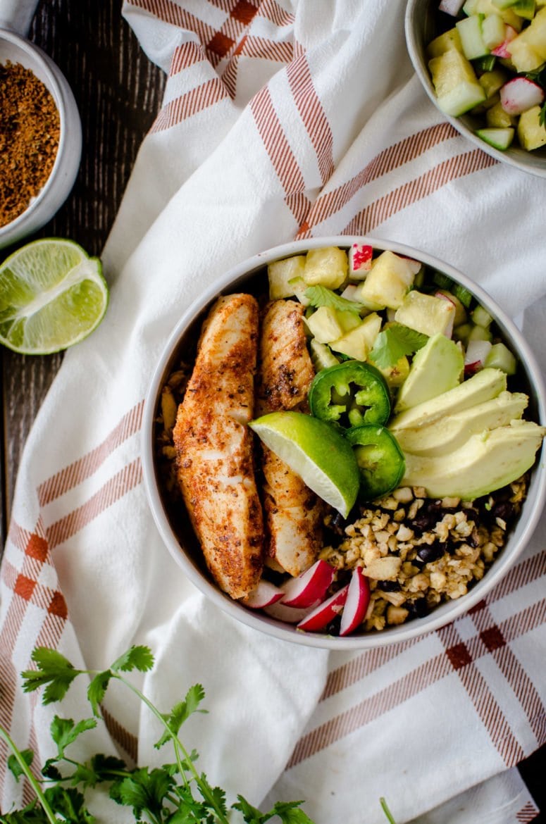 If you like "bowl food," you'll love this fresh and flavorful taco bowls with spicy pan-seared fish, plantain fried rice, black beans, and a juicy pineapple salsa! A fun take on an easy fish taco recipe. 
