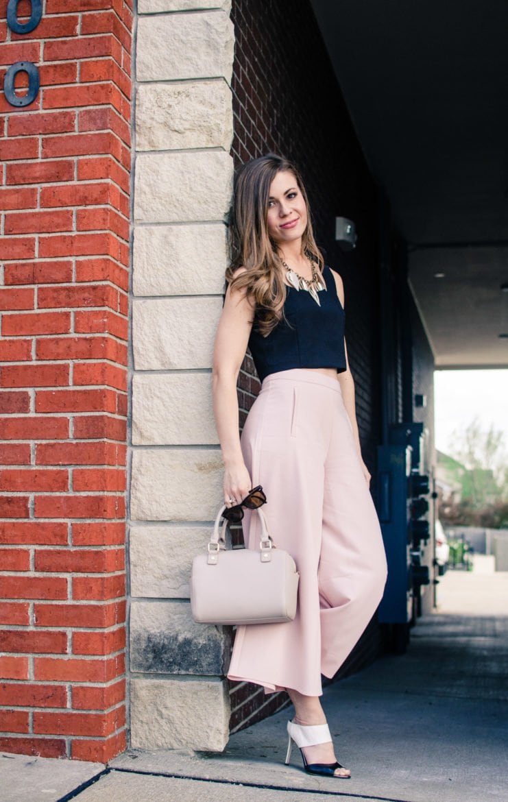 Blush pink culottes paired with a cropped black shell and Sam Edelman heels with a nude bag and necklace. Elegant spring outfit idea!