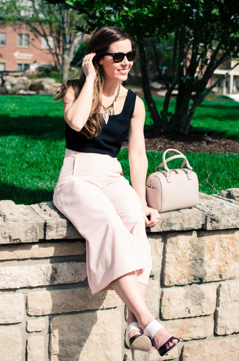 Blush pink culottes paired with a cropped black shell and Sam Edelman heels with a nude bag and necklace. Elegant spring outfit idea!