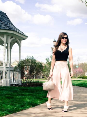 Blush pink culottes paired with a cropped black shell and Sam Edelman heels with a nude bag and necklace. Elegant spring outfit idea!