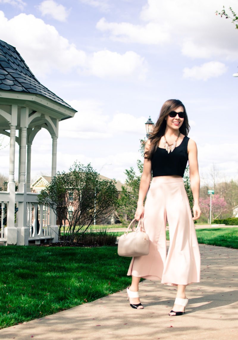 Blush pink culottes paired with a cropped black shell and Sam Edelman heels with a nude bag and necklace. Elegant spring outfit idea!