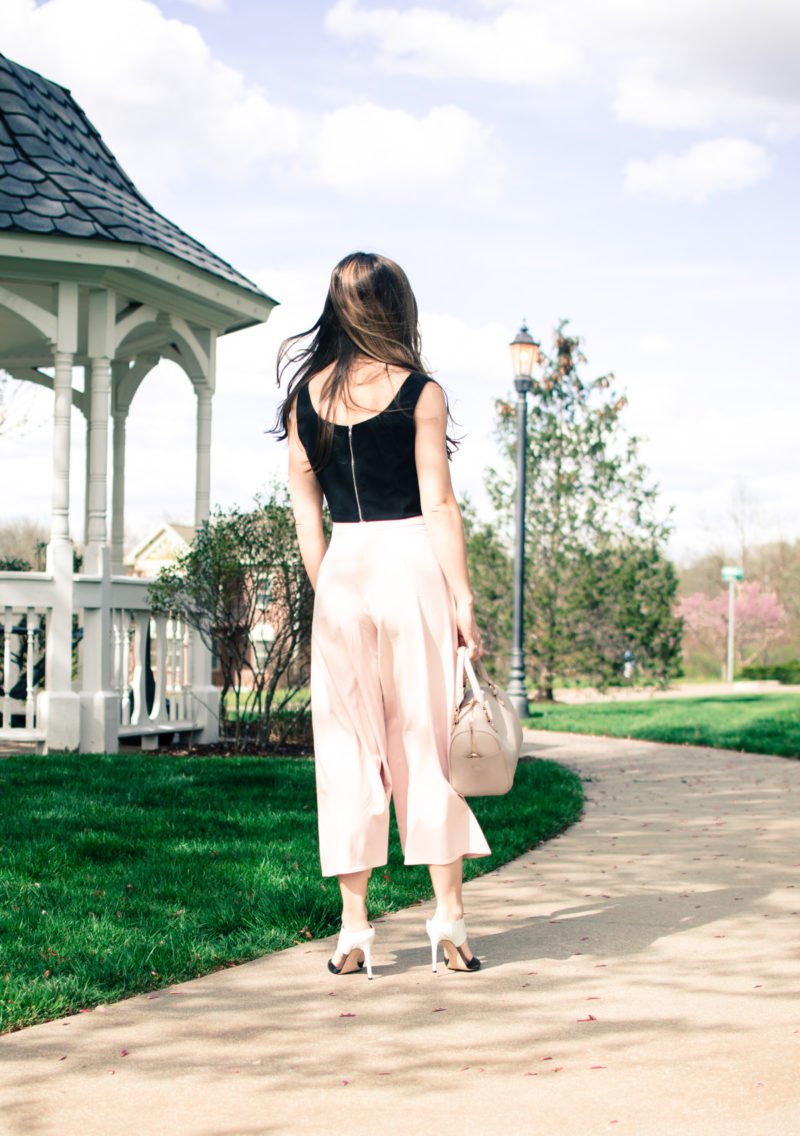 Blush pink culottes paired with a cropped black shell and Sam Edelman heels with a nude bag and necklace. Elegant spring outfit idea!