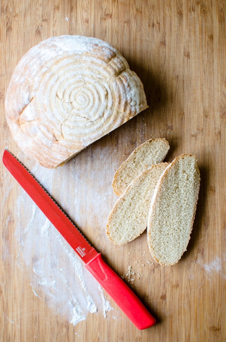 A sliced loaf of sourdough bread on a cutting board. 