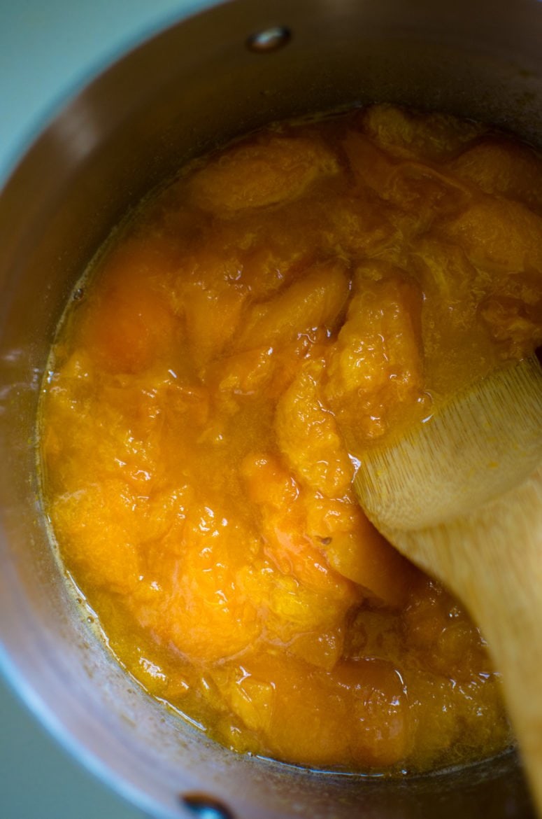 Apricots in a pot being boiled and reduced and broken down. 