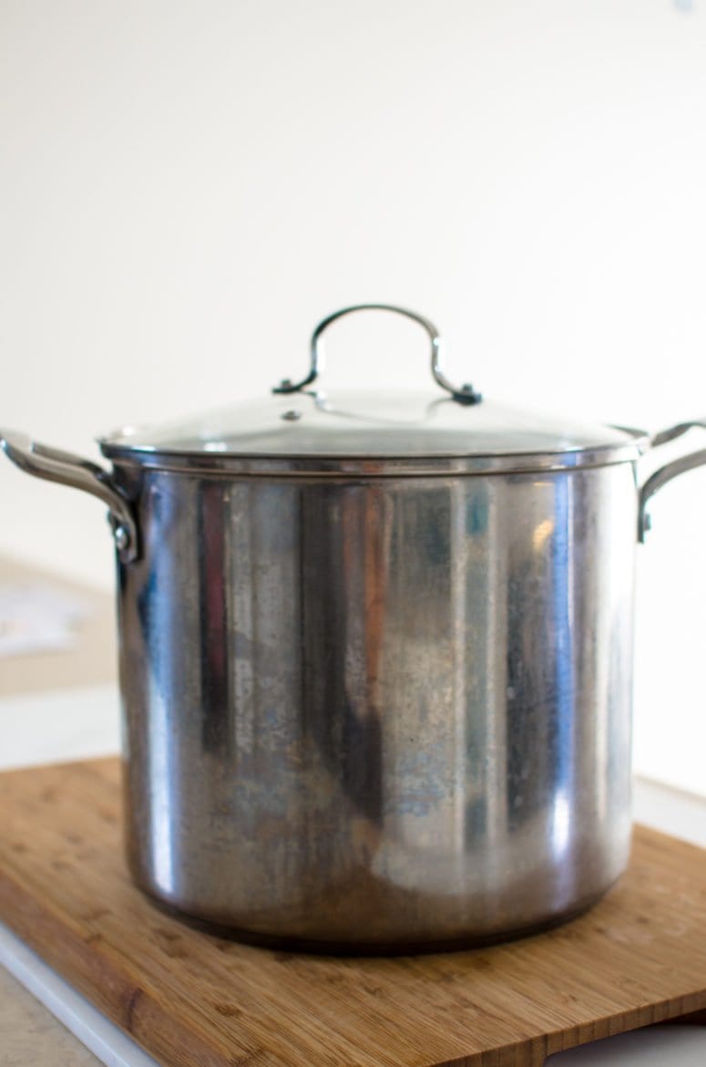 A jam pot on a cutting board.