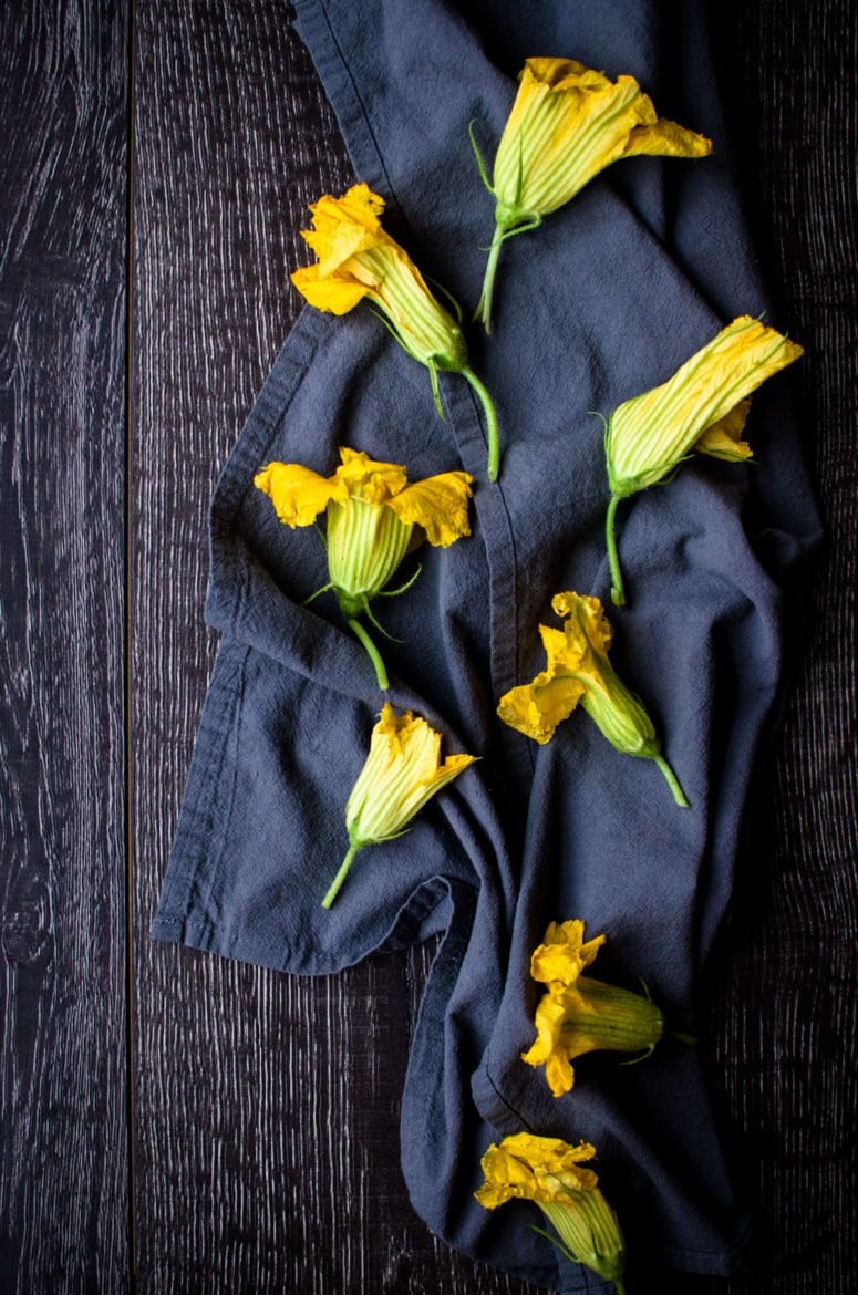 Squash blossoms on a blue dish towel. 