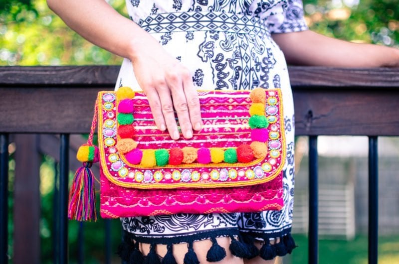 Pom Pom and tassel details are one of the summer's hottest fashion trends. This look features a pom pom clutch and cold shoulder romper with tassel detail. 