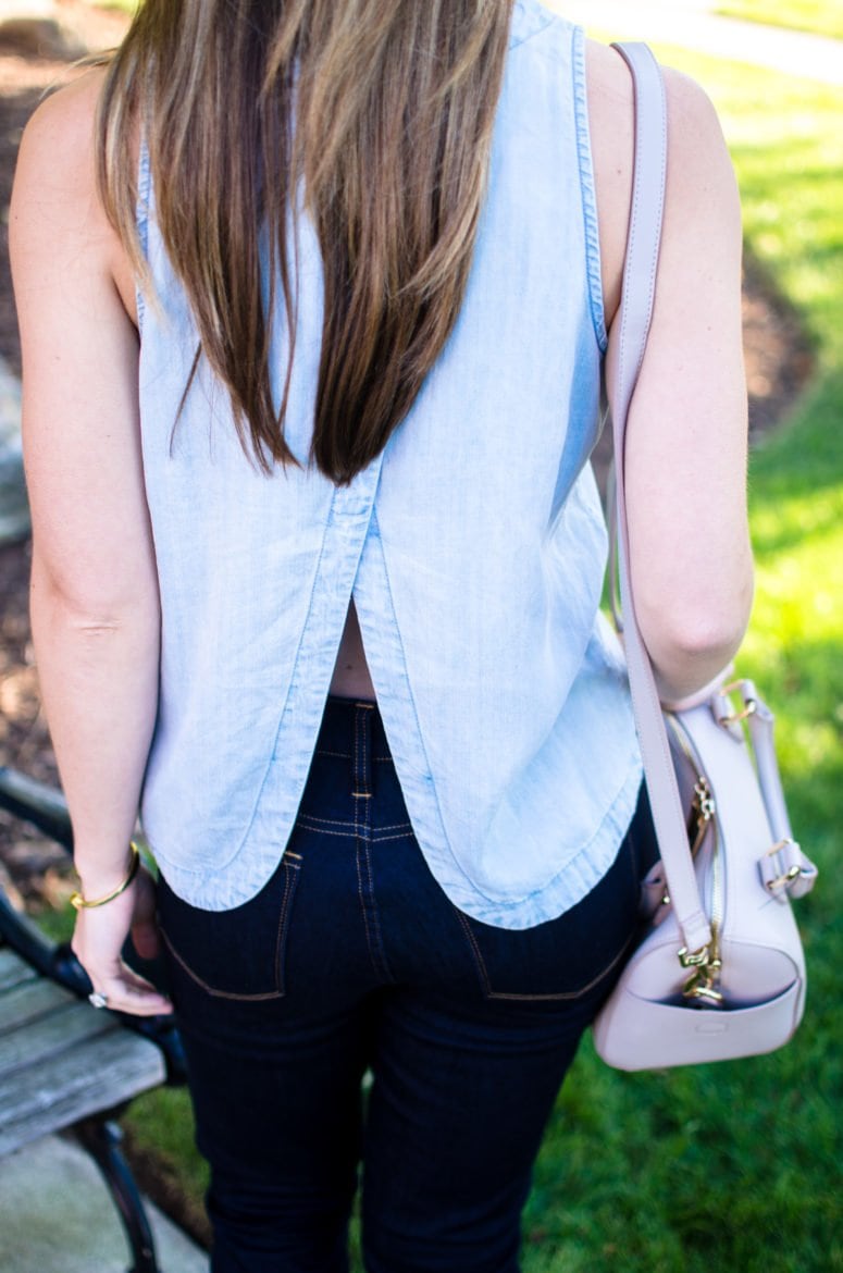 A chic and sophisticated denim on denim look that's perfect for fall transition fashion. High waisted jeans in a dark wash with an open-back chambray shirt. 