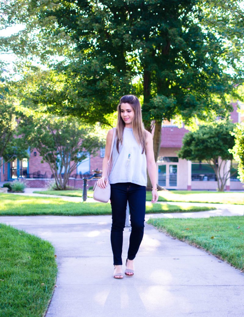 A chic and sophisticated denim on denim look that's perfect for fall transition fashion. High waisted jeans in a dark wash with an open-back chambray shirt. 