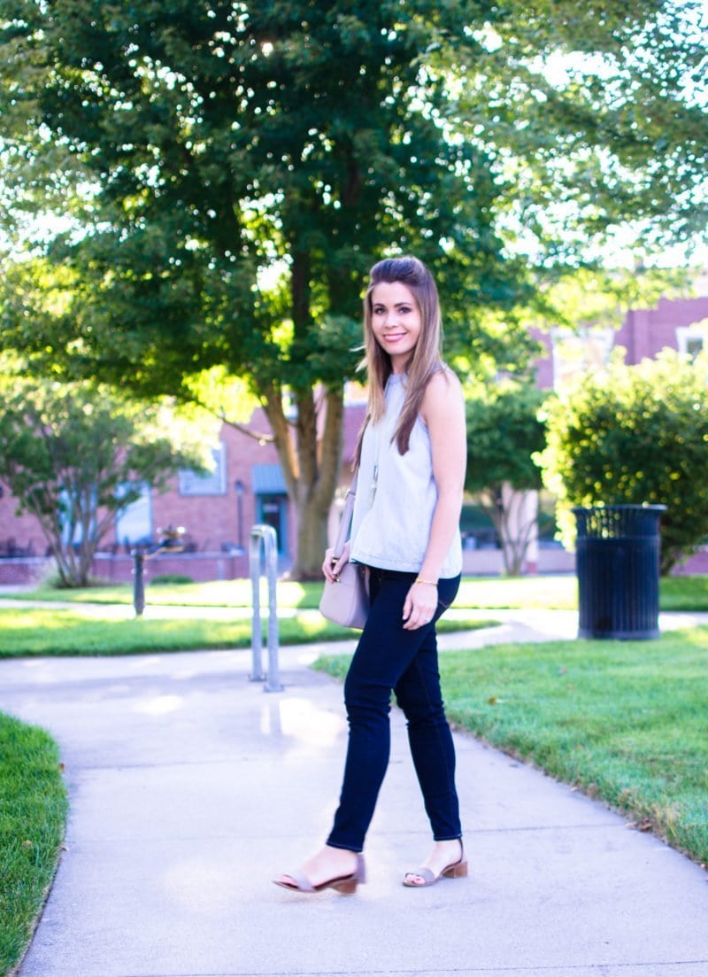 A chic and sophisticated denim on denim look that's perfect for fall transition fashion. High waisted jeans in a dark wash with an open-back chambray shirt. 