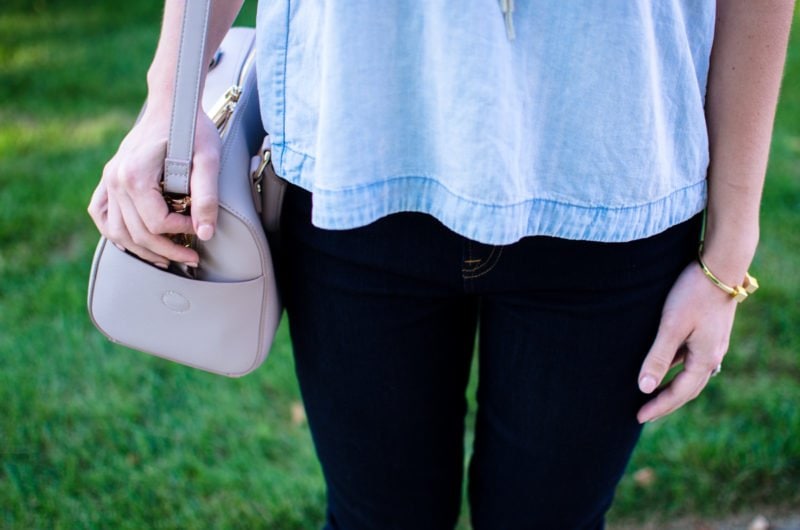 A chic and sophisticated denim on denim look that's perfect for fall transition fashion. High waisted jeans in a dark wash with an open-back chambray shirt. 