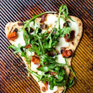 This recipe for BLT Naan Pizza is my favorite way to enjoy a BLT in the winter time! Smokey bacon, sweet roasted tomatoes, and peppery arugula on freshly made naan bread!