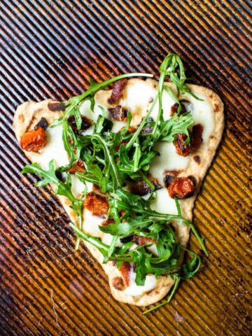 This recipe for BLT Naan Pizza is my favorite way to enjoy a BLT in the winter time! Smokey bacon, sweet roasted tomatoes, and peppery arugula on freshly made naan bread!