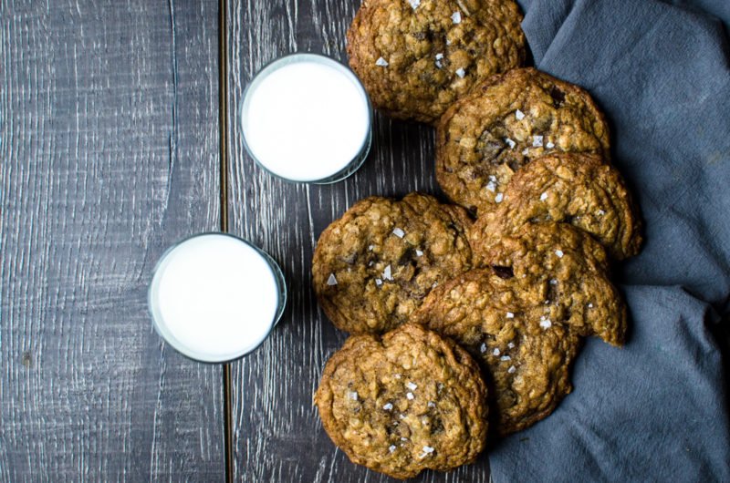 Two cups of milk seen with 6 cookies. 