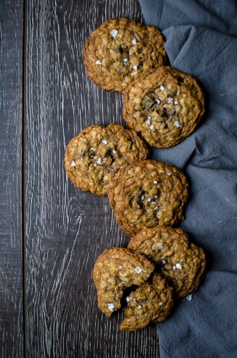 Six chocolate chip cookies on a wooden tray.