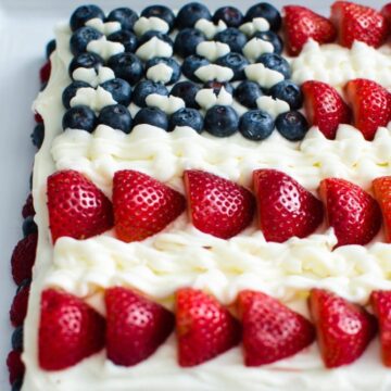 This fresh berry flag cake is made from scratch and is moist, flavorful, and perfect to serve for the 4th of July or Memorial Day! It's decorated with loads of berries and cream cheese frosting!