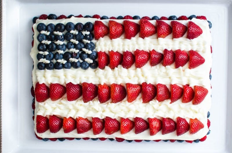 American flag cake made with berries and cream cheese frosting. 