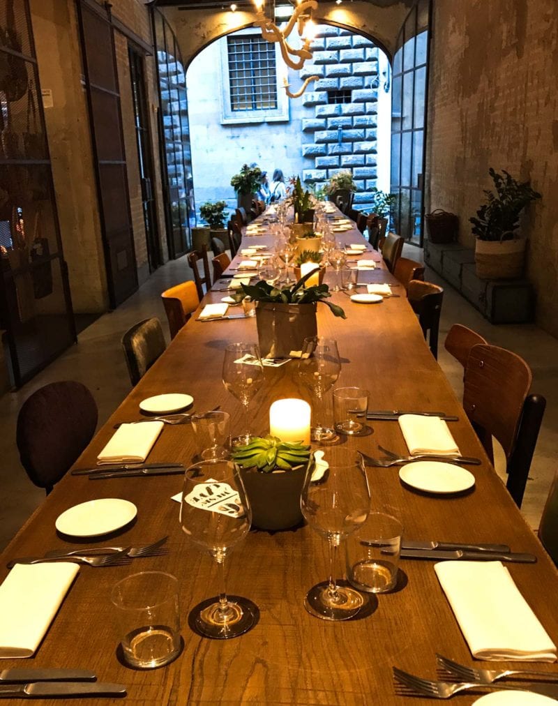 A long table with table settings at each seat in Le Menagere. 