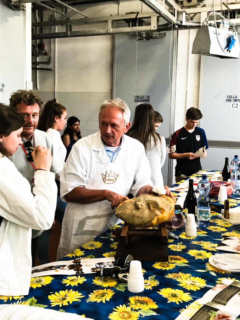 A salumeria owner demonstrating how to slice Prosciutto di Parma. 