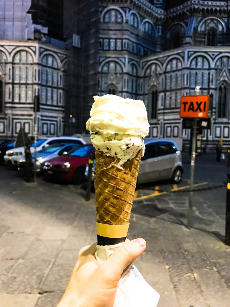 A gelato cone pictured in front of an Italian street. 