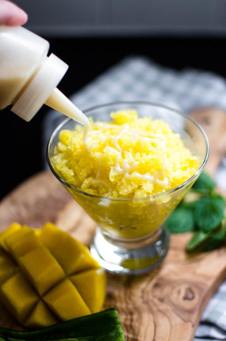 Mango Granita being topped with condensed milk.