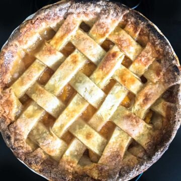 This peach Bellini pie recipe is made with market fresh summer peaches poached in sweet Moscato wine and baked in a buttery, flaky, lattice-top crust.