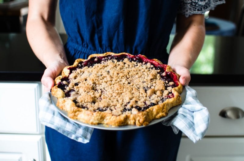 Chef holding mixed berry pie. 