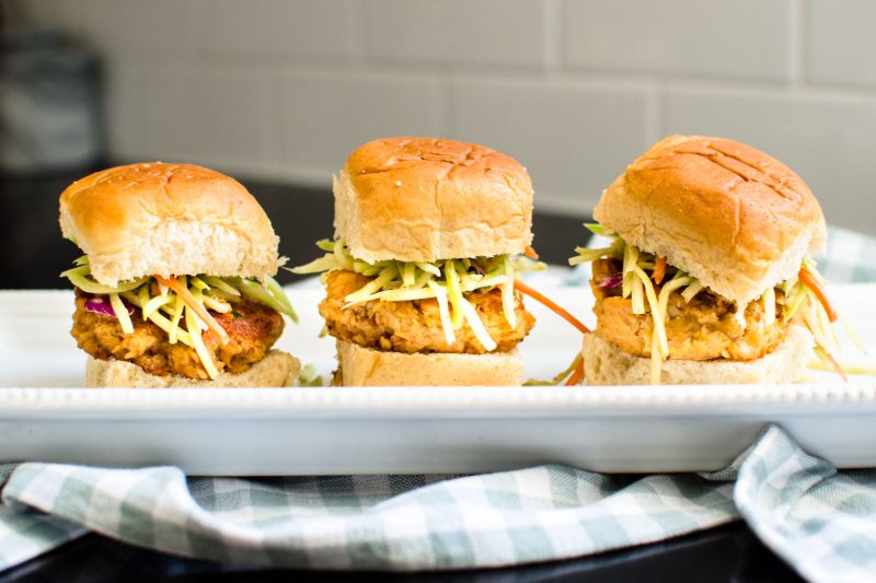 Three Buffalo Salmon Sliders pictured side by side on a white serving tray. 