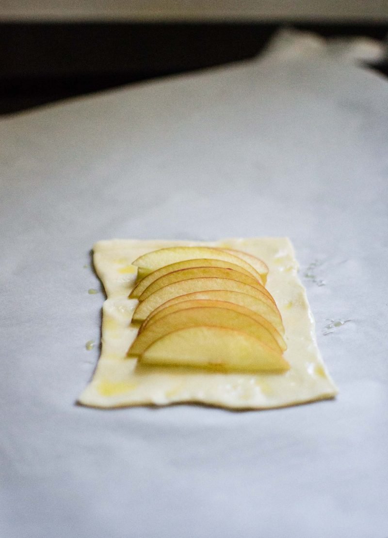 Pastry square with sliced apple on top. A step in making apple tart. 