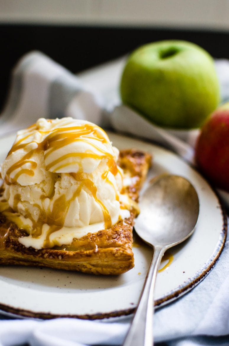 A slice of apple tart with vanilla ice cream on top. 