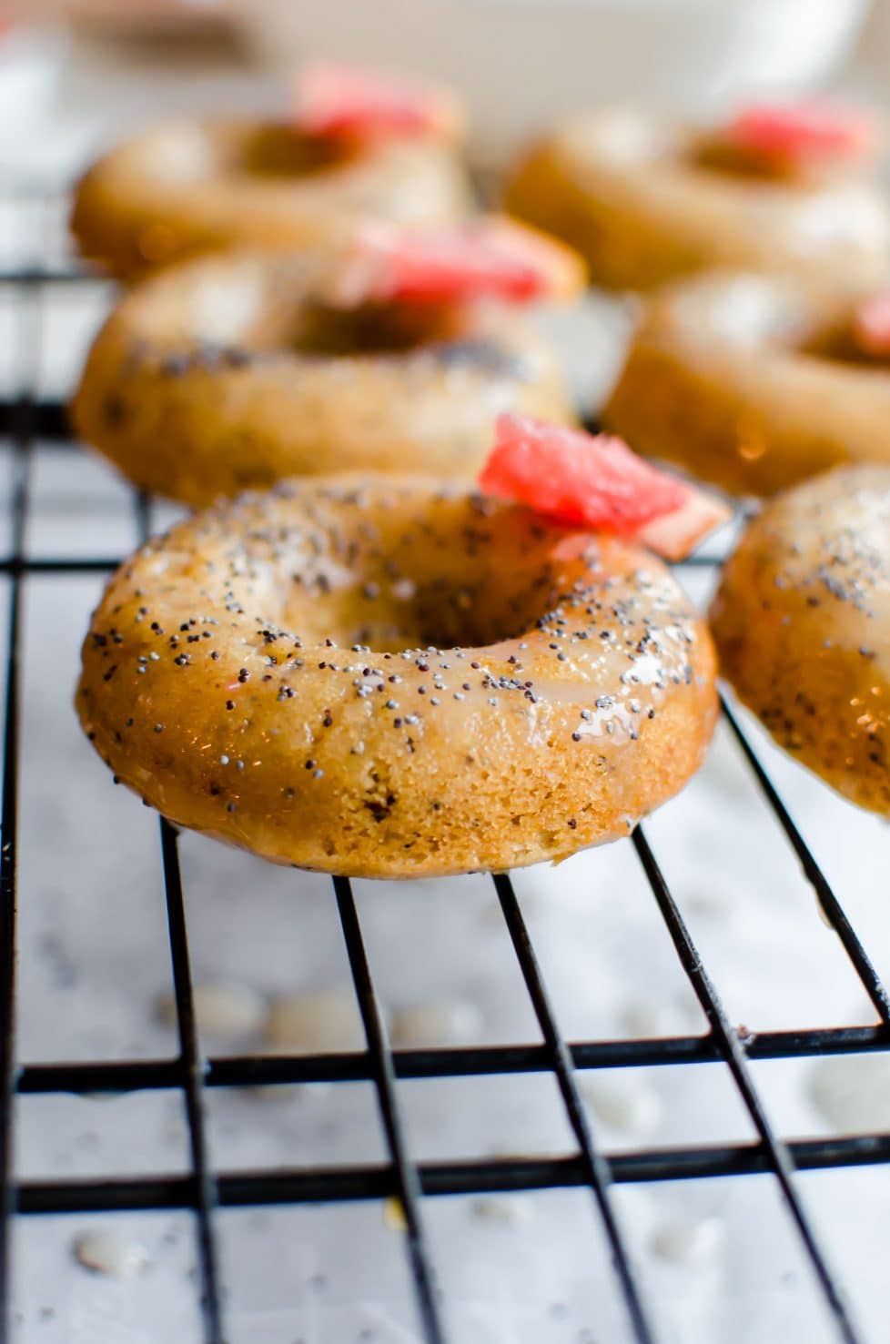 This recipe for Grapefruit Poppy Seed Donuts is perfect for a spring brunch or garden party! They are made with whole grain flour, wholesome Greek yogurt, and coconut sugar with a light citrus glaze. #grapefruit #springrecipes #sweetcayenne