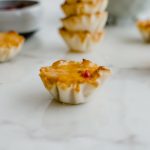 Angled overhead view of a single pimento cheese tartlet