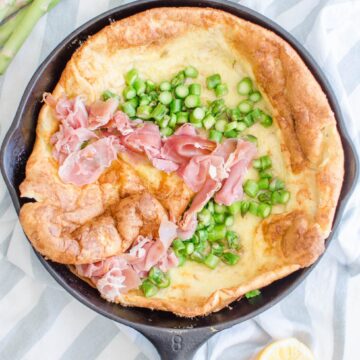 This recipe for a savory Dutch Baby is loaded with fresh springtime flavor and features a nutty Raspberry cheese, tender bites of fresh Asparagus, and salty shaved Serrano ham.