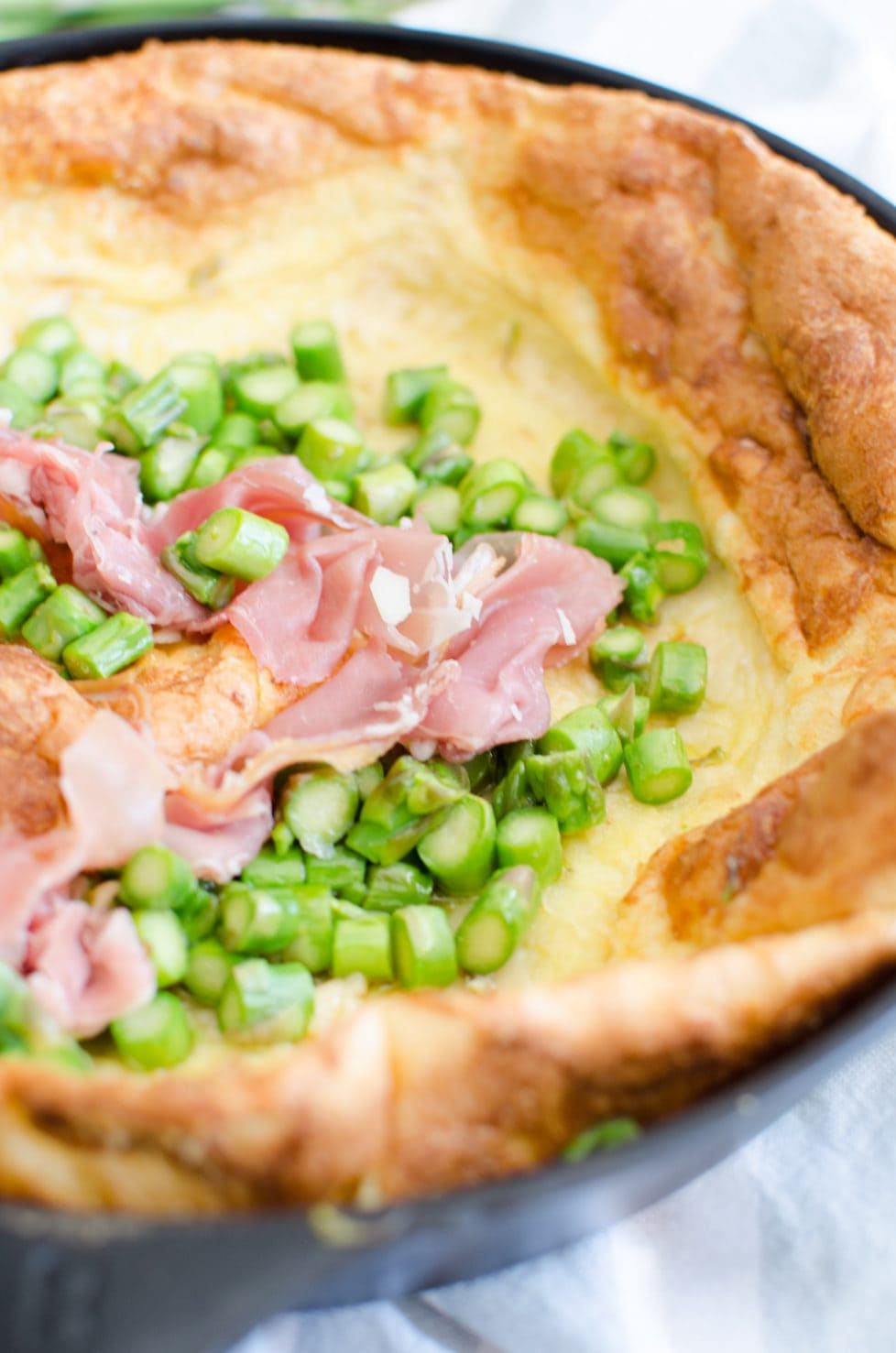 This recipe for a savory Dutch Baby is loaded with fresh springtime flavor and features a nutty Raspberry cheese, tender bites of fresh Asparagus, and salty shaved Serrano ham. 