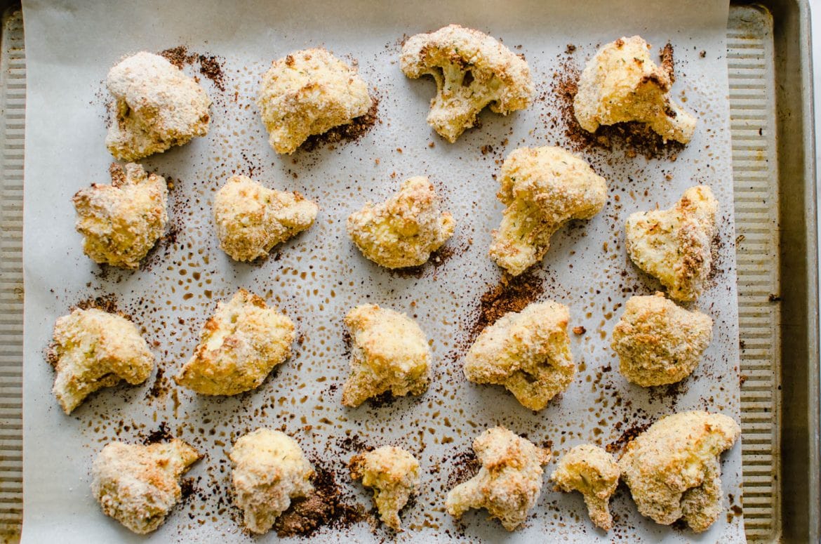 An overhead shot of breaded baked cauliflower on a baking sheet. 