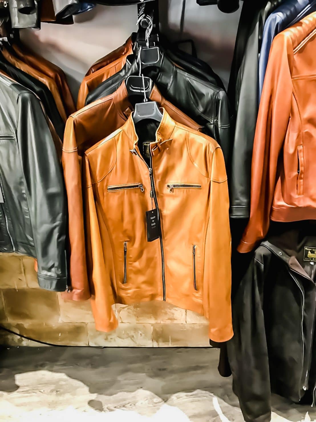 A photo of a row of leather jackets for men in a store. 