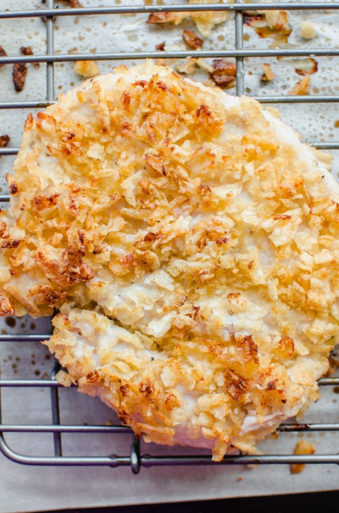 A piece of potato chip-crusted chicken on a wire cooling rack.