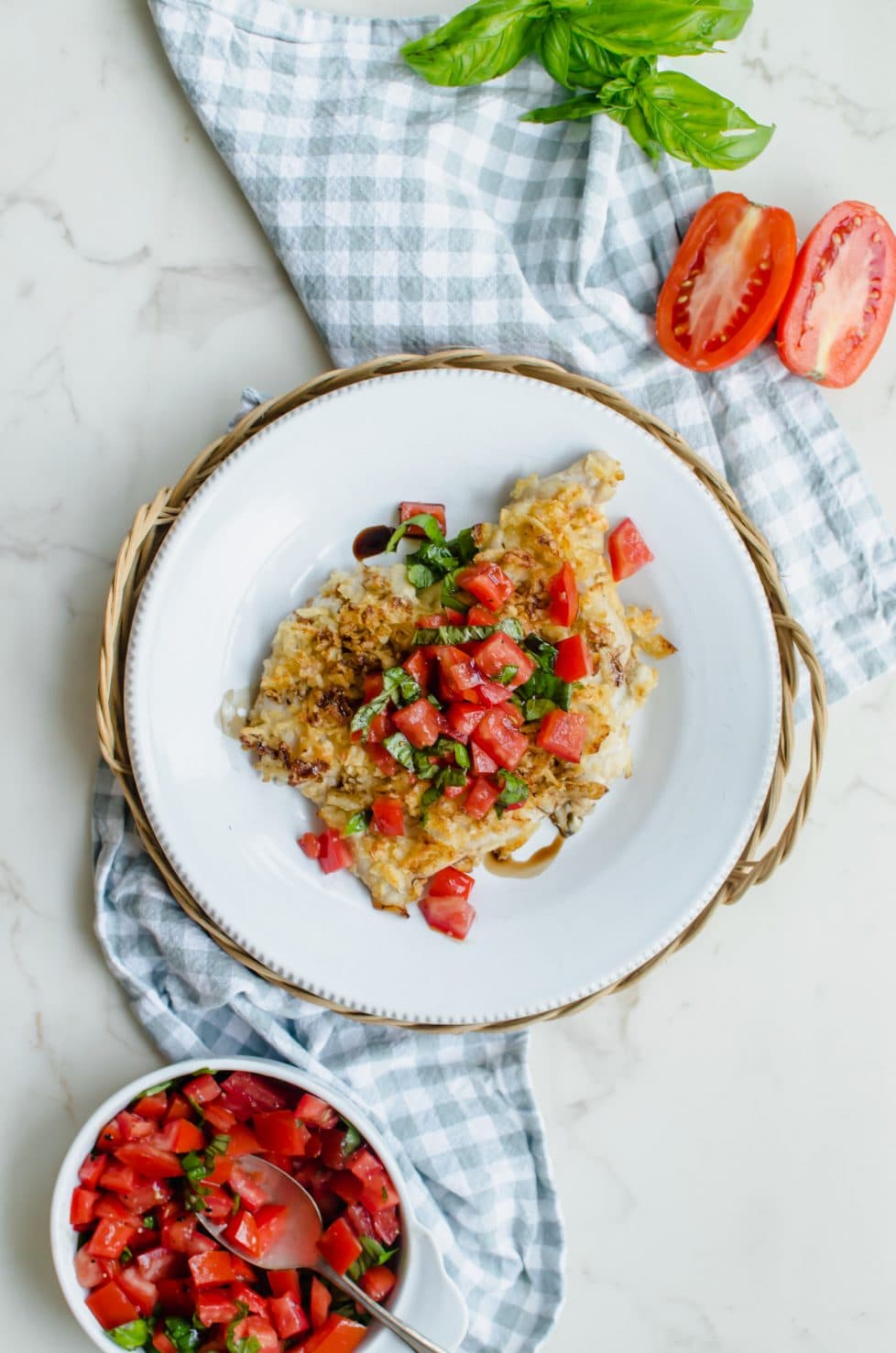 An overhead shot of a piece of bruschetta potato chip chicken on a white plate. 