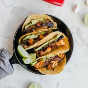 An overhead shot of a cast iron skillet filled with Korean-style beef tacos with roasted cauliflower.