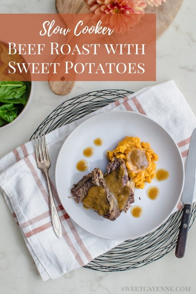 An overhead shot of a stone plate with beef pot roast, sweet potatoes, and cider gravy. A bowl of raw spinach is on the side. There is text overlay with the recipe title for Pinterest. 